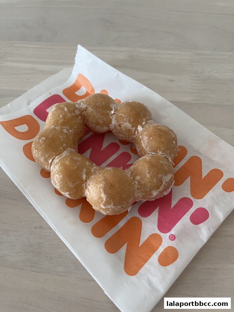 A close-up of a donut on a Dunkin' Donuts branded paper.