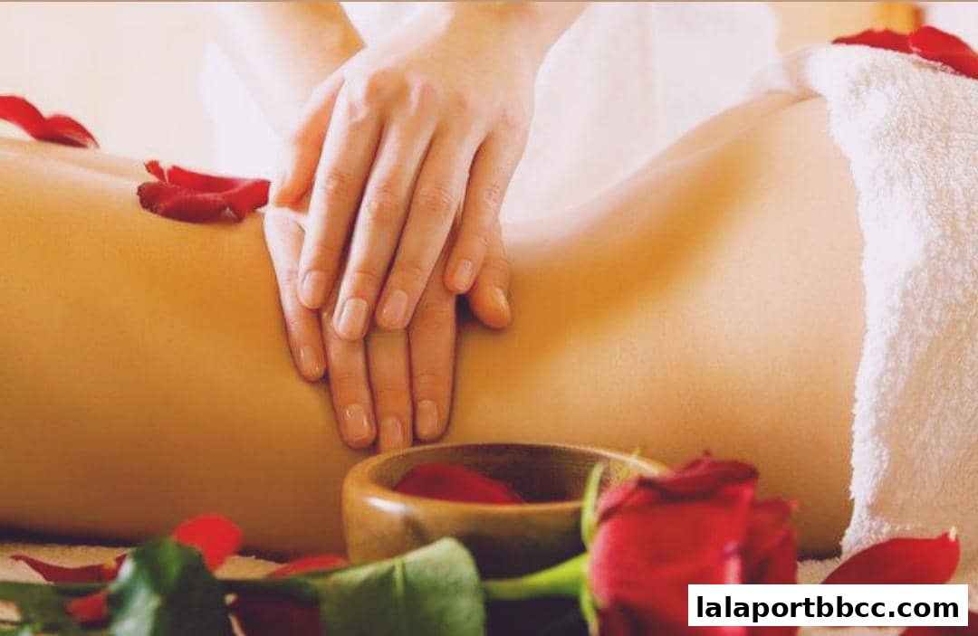 A close-up of hands giving a massage with rose petals and a towel.