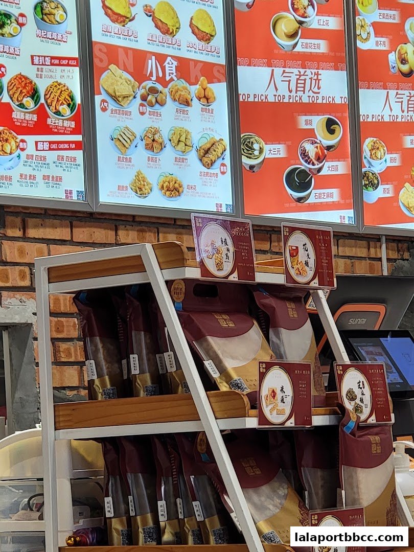A brightly lit menu board showcasing various Chinese desserts and snacks with enticing images and prices.