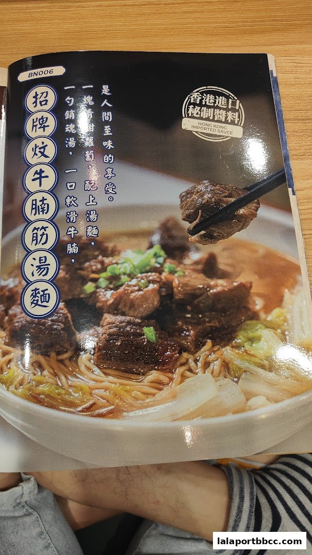 A close-up of a steaming bowl of beef noodle soup with tender beef and broth.