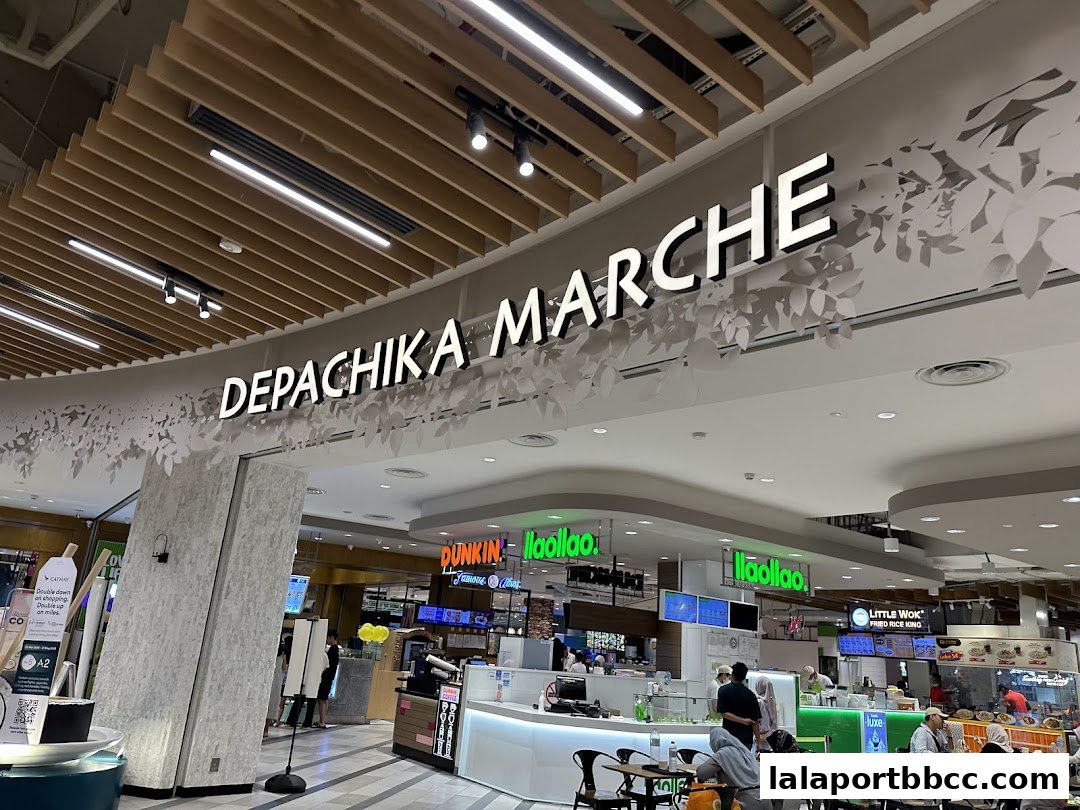 A wide view of a bustling food hall with various eateries and seating areas.