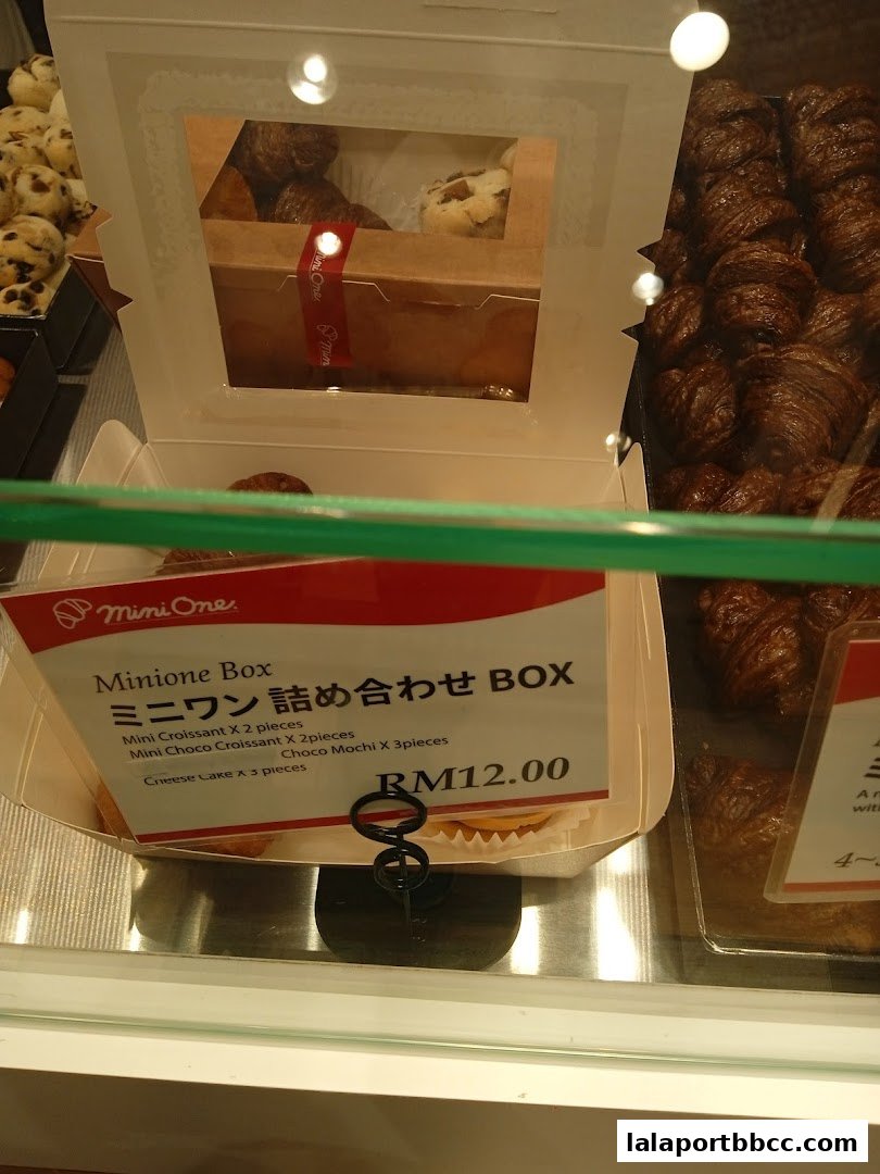 A box of assorted pastries from DONQ Mini One, featuring croissants and mochi.