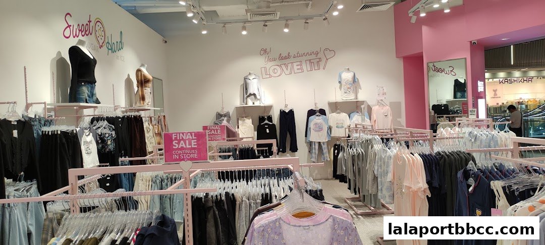 Interior of a clothing store with mannequins and racks of apparel, featuring a sale.