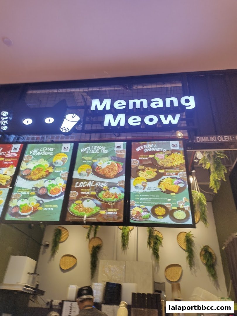 A brightly lit food stall with a large sign displaying various menu items.