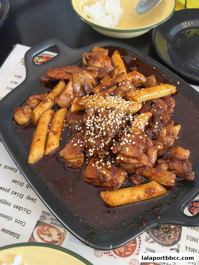 A close-up of a delicious Korean dish with chicken and rice cakes in a savory sauce.