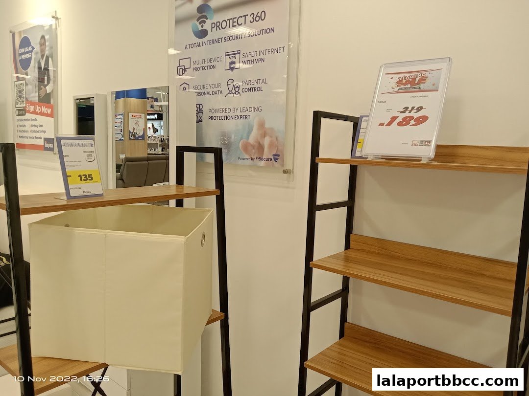 Shelving units display promotional signs and a storage bin inside a retail store.