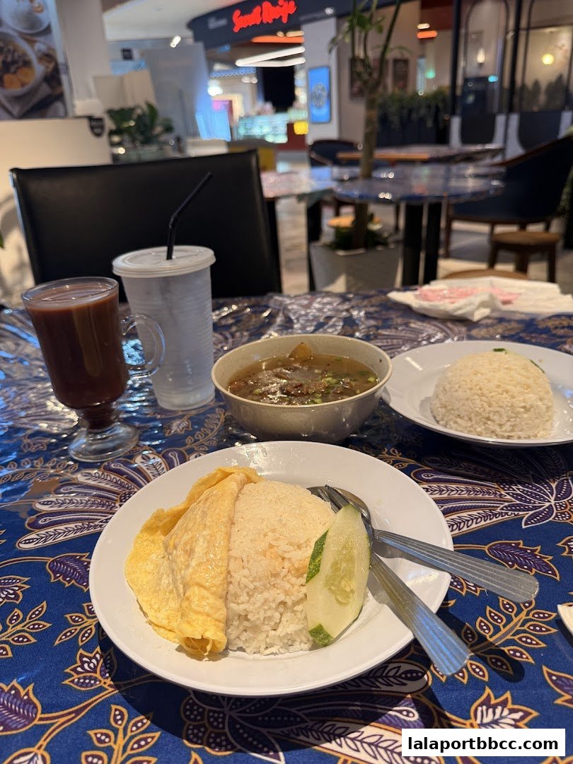 A table setting with rice dishes, soup, and drinks, likely in a restaurant.