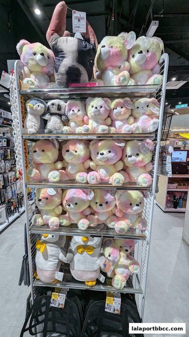 A display of colorful teddy bear plushies and penguin stuffed toys on shelves.
