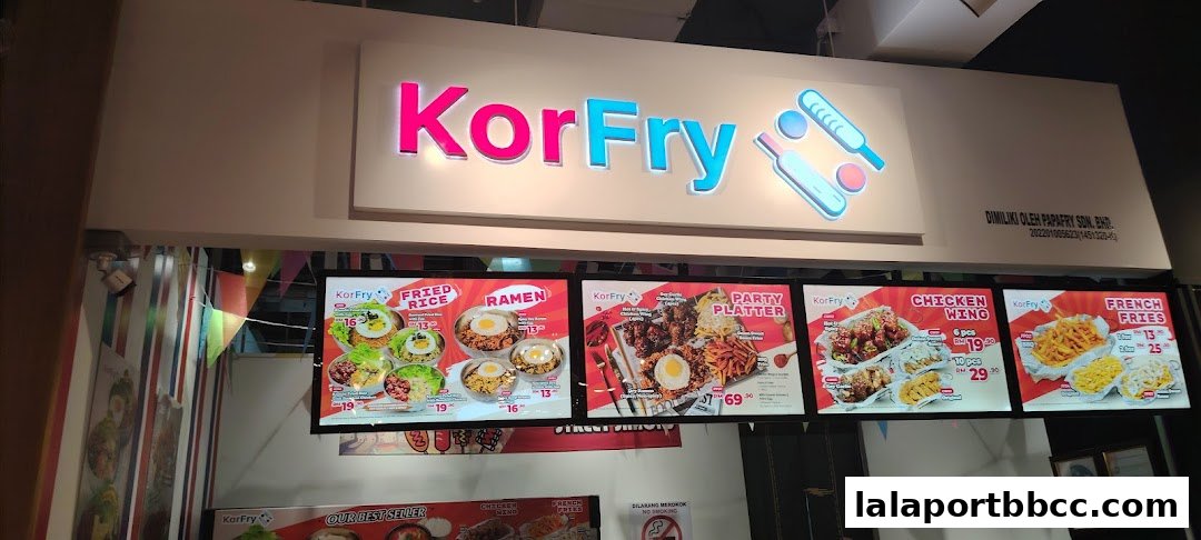 A brightly lit menu board for KorFry, showcasing various fried chicken and noodle dishes.