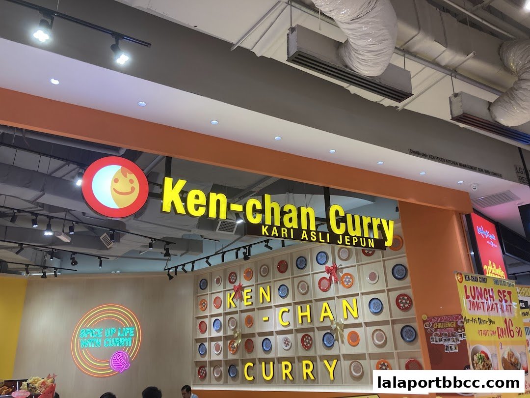 The exterior of Ken-chan Curry restaurant with its bright yellow signage and decorative plates.