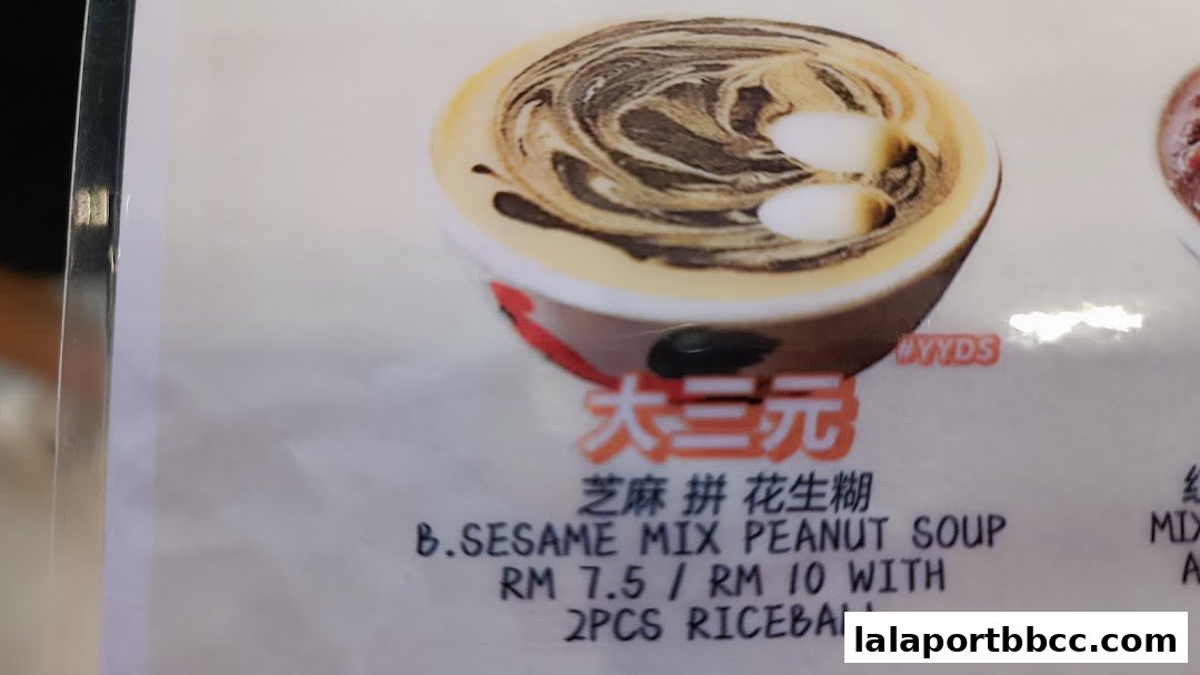 A close-up of a dessert menu item featuring sesame and peanut soup with rice balls.