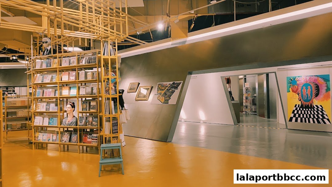 Interior of a modern bookstore with yellow shelving, books, and artwork on display.