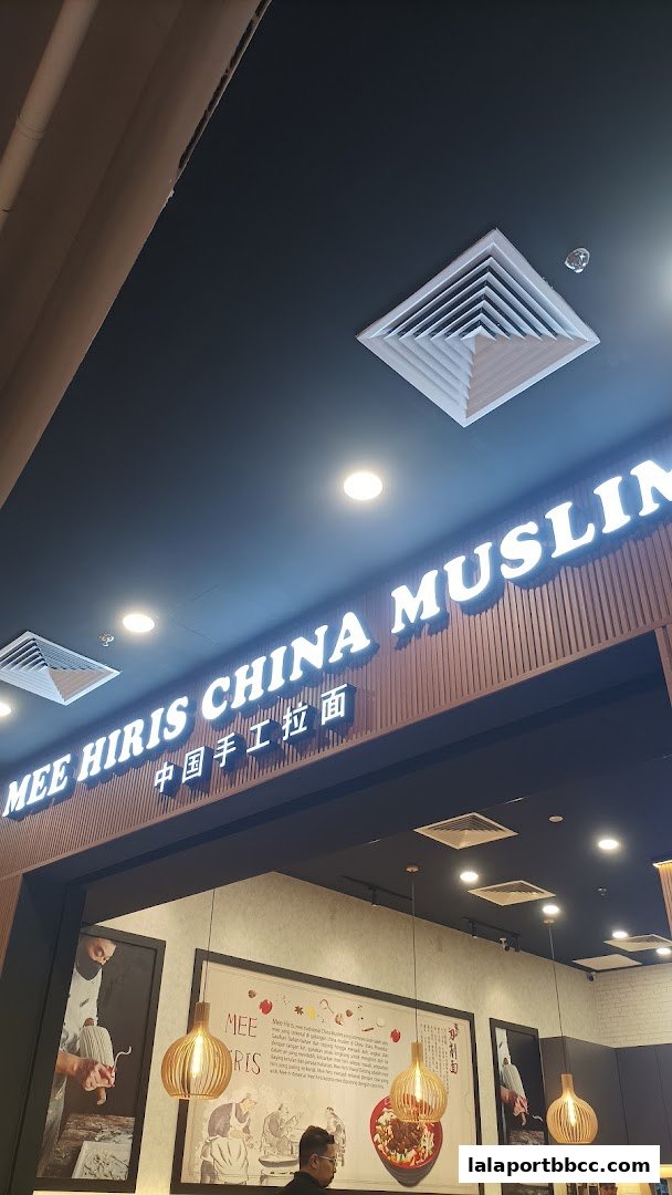 The illuminated sign for Mee Hiris China Muslim restaurant with Chinese characters below.