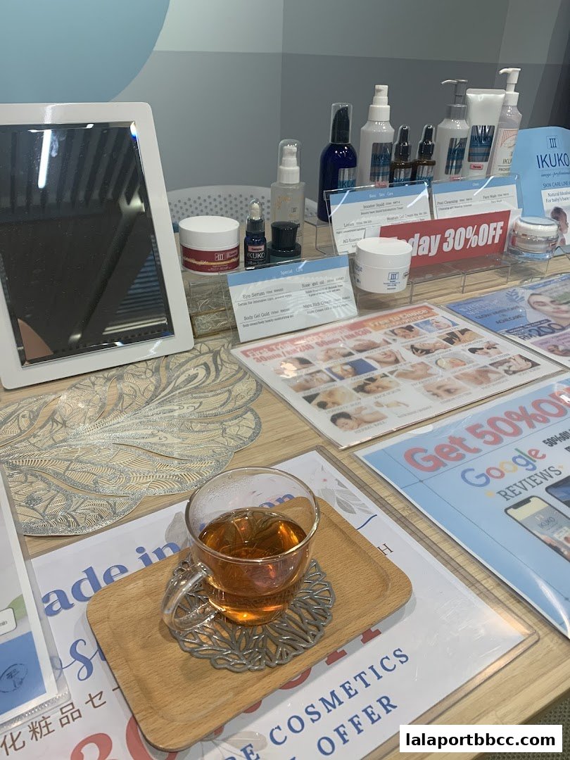 A display of IKUKO JAPAN BEAUTY skincare products with promotional flyers and a cup of tea.