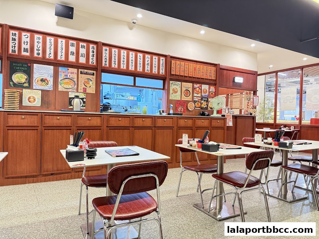 Interior of a Japanese ramen restaurant with tables and chairs set for dining.