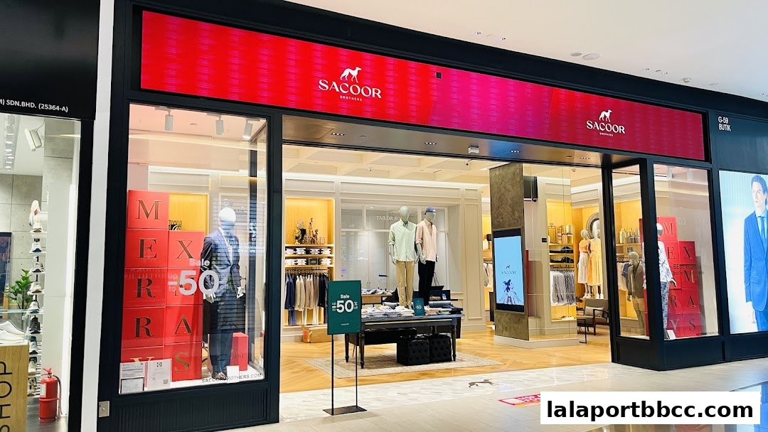 The Sacoor Brothers store front displays mannequins and sale signage, showcasing stylish menswear.