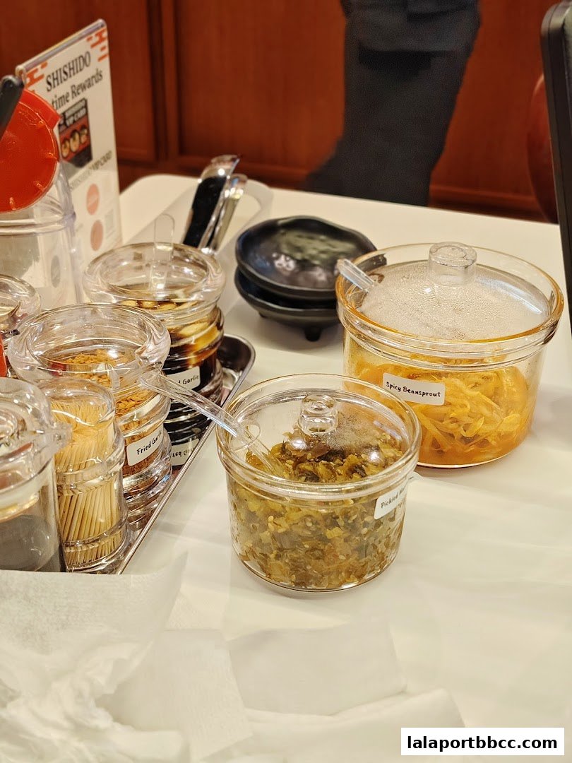 A table setting with various condiments and toothpicks at Menya Shishido Lalaport BBCC.
