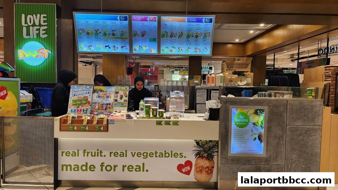 Boost Juice shop counter with staff, menus, and fresh ingredients displayed.