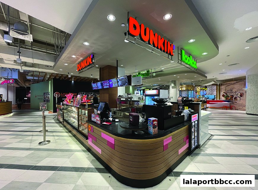 A Dunkin' Donuts counter with display cases filled with donuts and coffee machines.