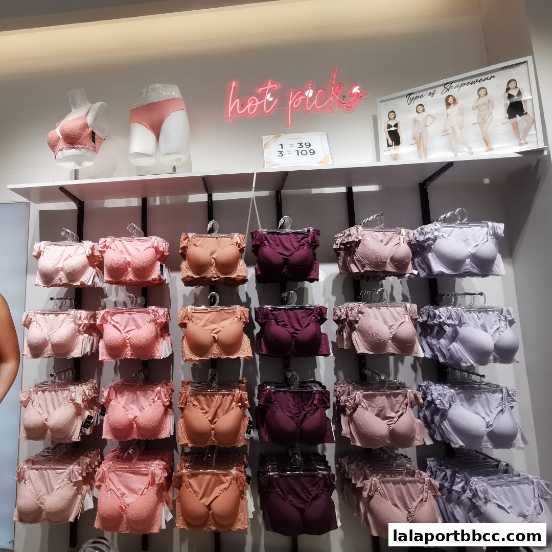 A display of lingerie sets in various colors, including pink, peach, and purple, on hangers.