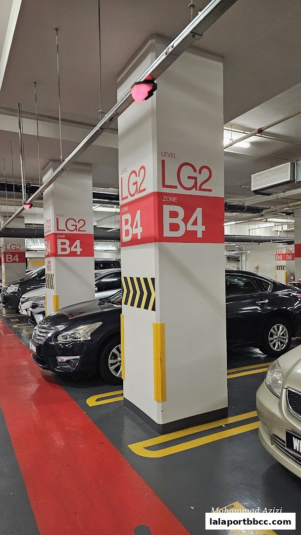 A parking garage with cars parked and clear signage indicating levels and zones.