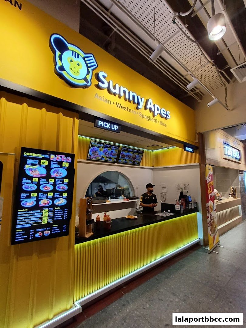 The Sunny Apes shop front with a bright yellow exterior and a digital menu board.