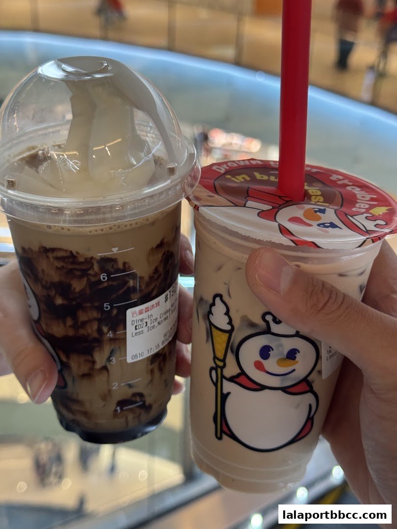 Two hands holding iced beverages from MIXUE, one with a chocolate drizzle and the other a milk tea.