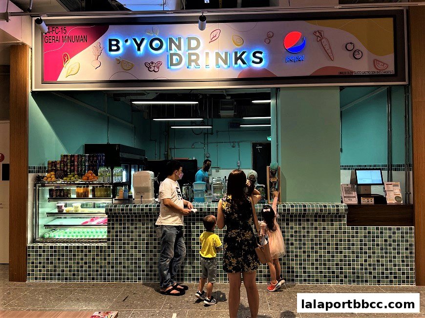 A family orders drinks at a brightly lit beverage shop called B'Yond Drinks.