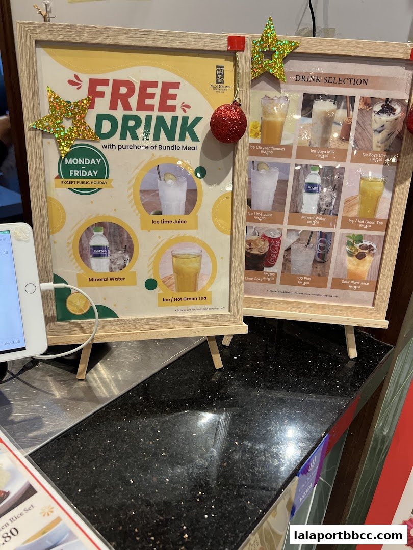A promotional sign for a free drink with a bundle meal purchase at Nam Heong Chicken Rice.