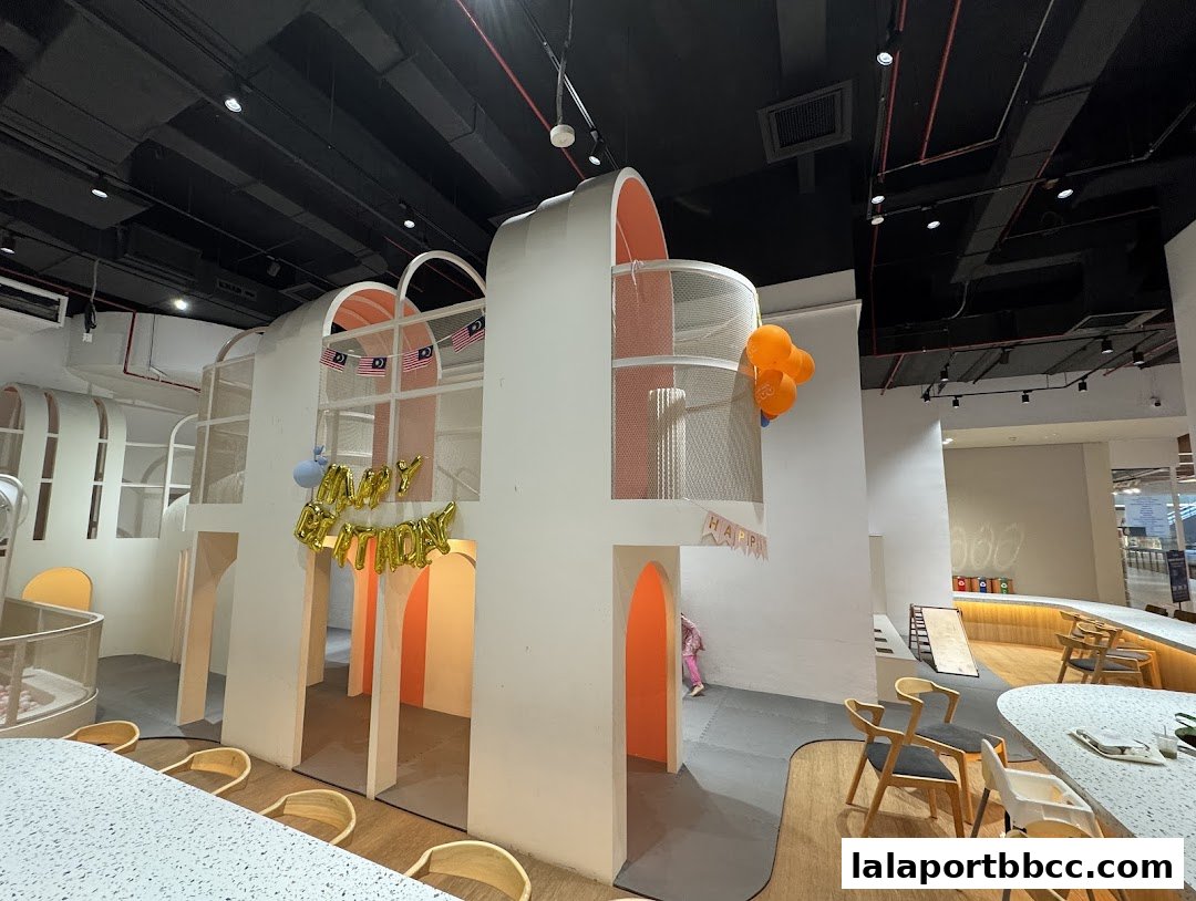 A brightly lit indoor playground with colorful decorations and seating areas.