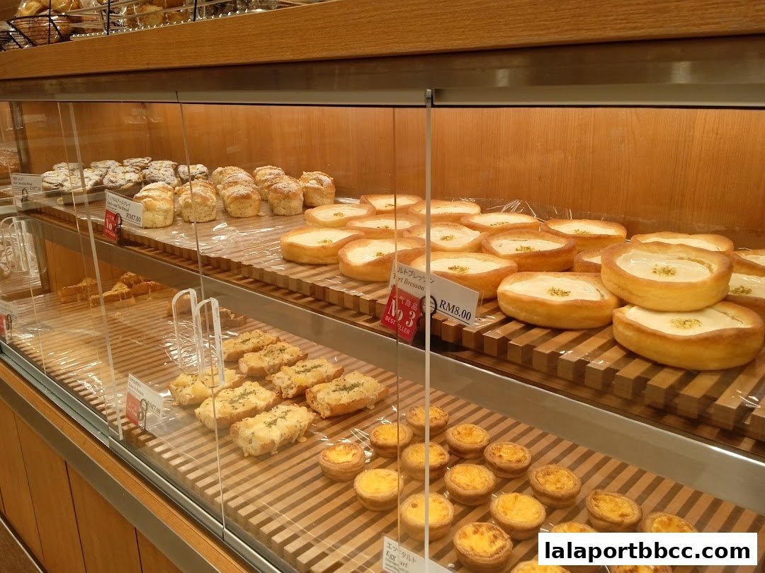 A display case filled with various baked goods, including tarts, bread, and pastries.