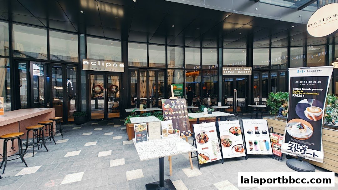 The exterior of the 'eclipse cafe & meal' shop with outdoor seating and promotional displays.