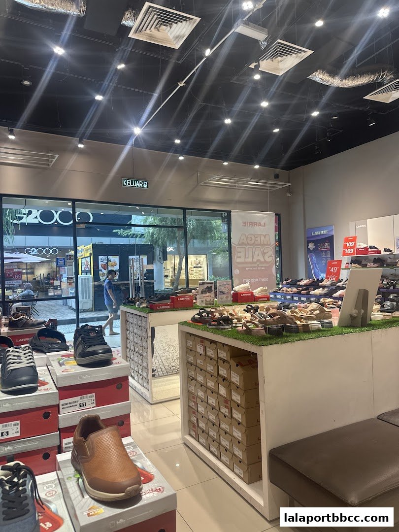 Interior view of a shoe store showcasing various footwear and sale banners.