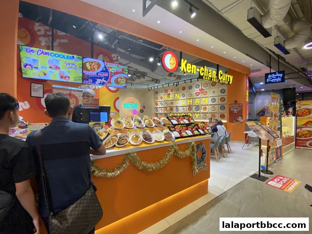 A vibrant Ken-chan Curry shop with displayed food items and customers ordering.