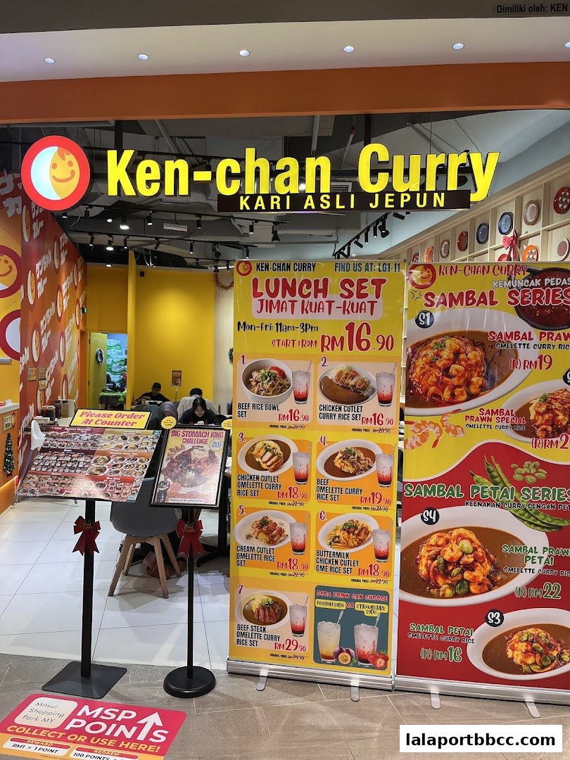 The exterior of Ken-chan Curry restaurant with a prominent sign and displayed lunch sets and menu items.