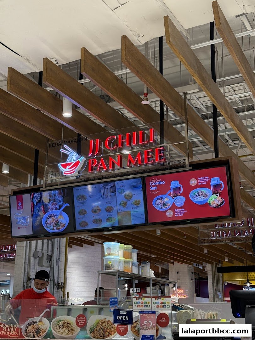 A food stall displaying its menu and signature dishes, with staff preparing food.