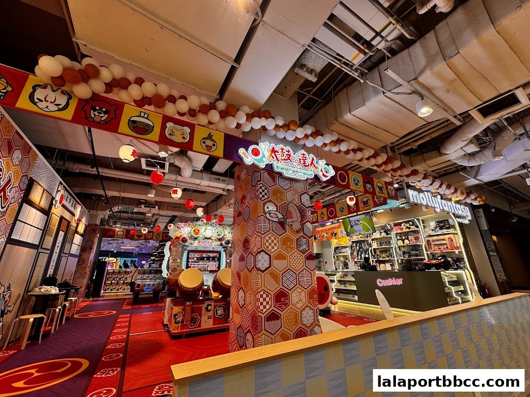 Interior view of a brightly decorated entertainment center with arcade games and merchandise.