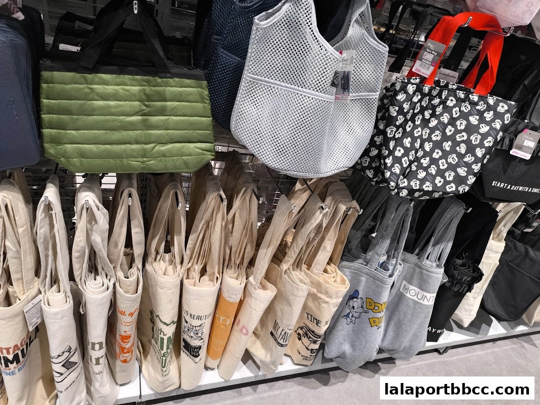 A variety of tote bags and other bags displayed on shelves and hanging racks.
