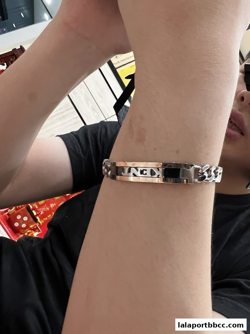 A person wearing a stylish silver bracelet with the name 'KENT' engraved on it.