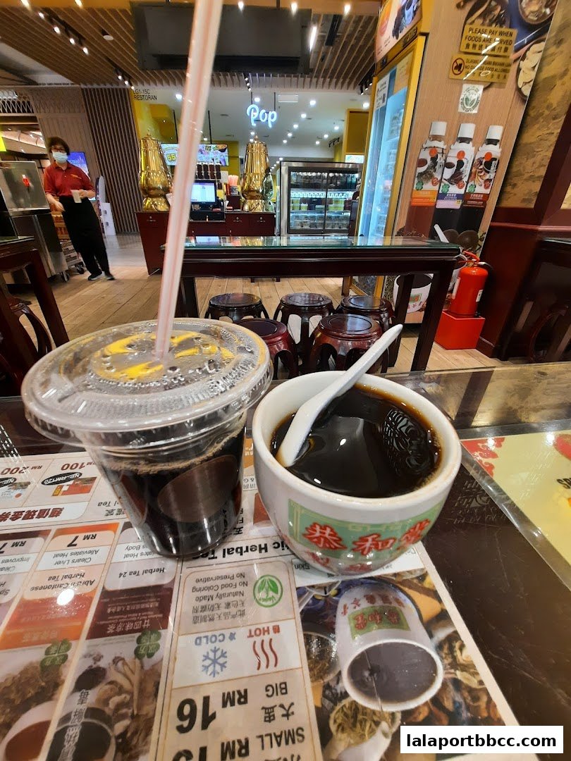 A close-up of herbal jelly and a drink from Koong Woh Tong, with the shop interior visible.
