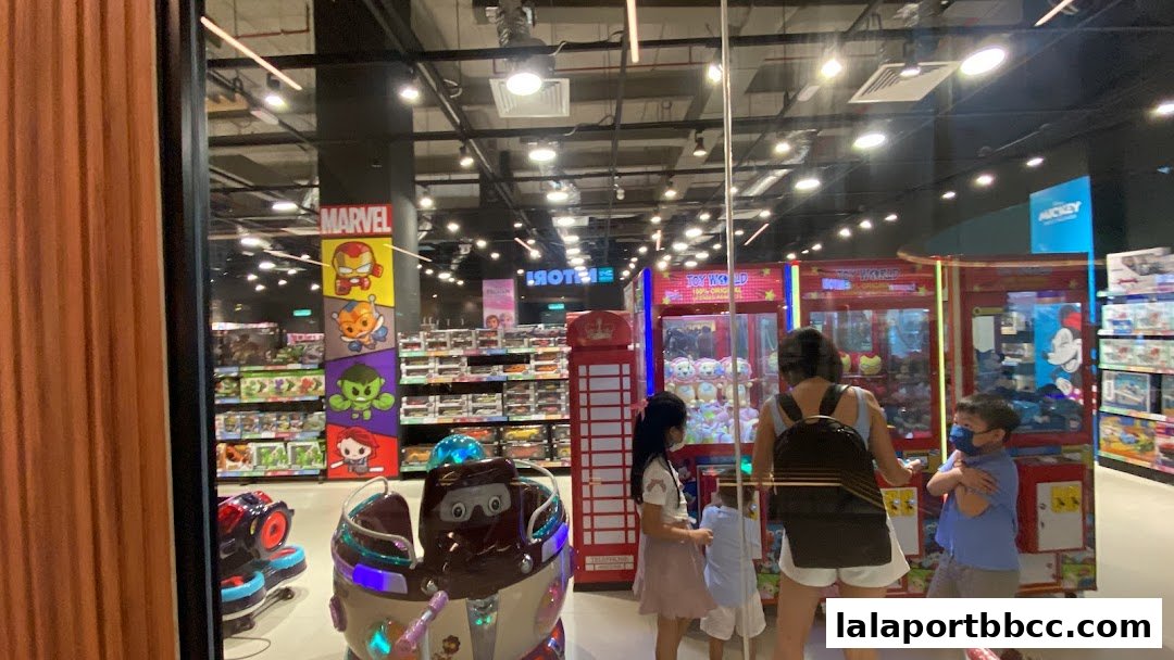 View of a brightly lit toy store interior with Marvel characters and claw machines.