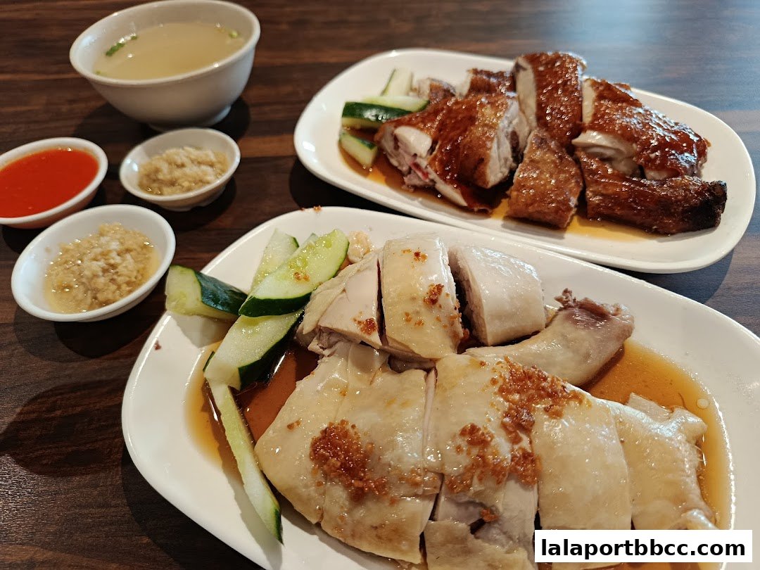 Two plates of delicious chicken rice with accompanying sauces and soup.