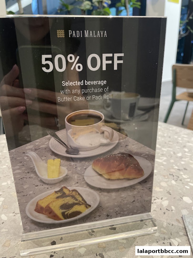 A sign advertising 50% off selected beverages with purchase of Butter Cake or Padi Roll.