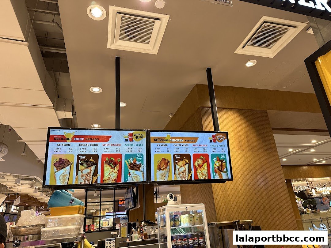 A digital menu board displaying various beef and chicken kebabs with prices and images.