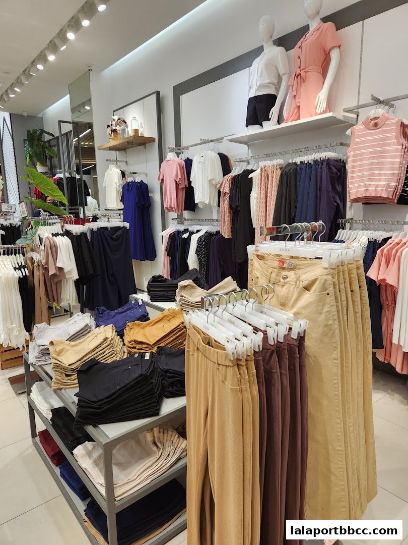Interior view of a clothing store displaying a variety of apparel on racks and shelves.