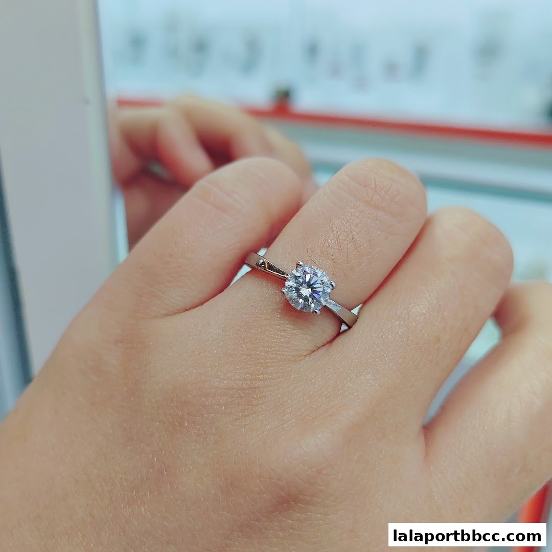 A hand wearing a sparkling diamond ring in a jewelry store.