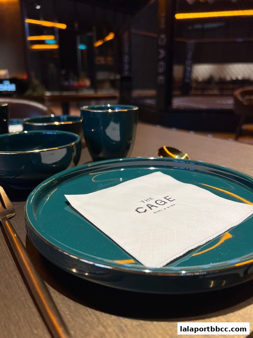 A close-up of a table setting with teal plates, bowls, and cups at The Cage.
