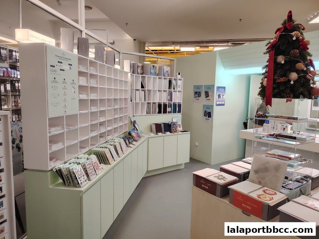 Interior of a stationery shop with shelves of notebooks, art kits, and a Christmas tree.