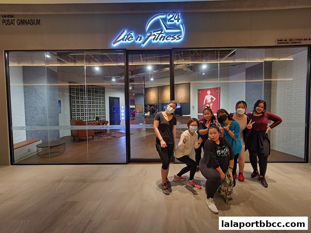 A group of people posing in front of the LifenFitness gym entrance.