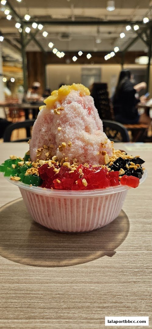 A refreshing bowl of shaved ice dessert with colorful jellies and peanuts.